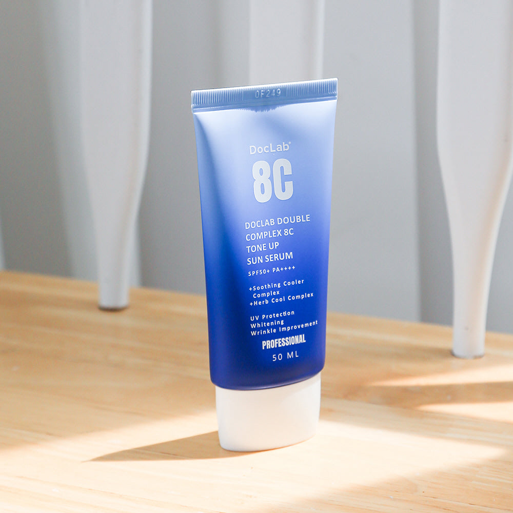 Doclab 8C Tone Up Sun Serum placed on wood surface, ideal for UV protection and soothing care.