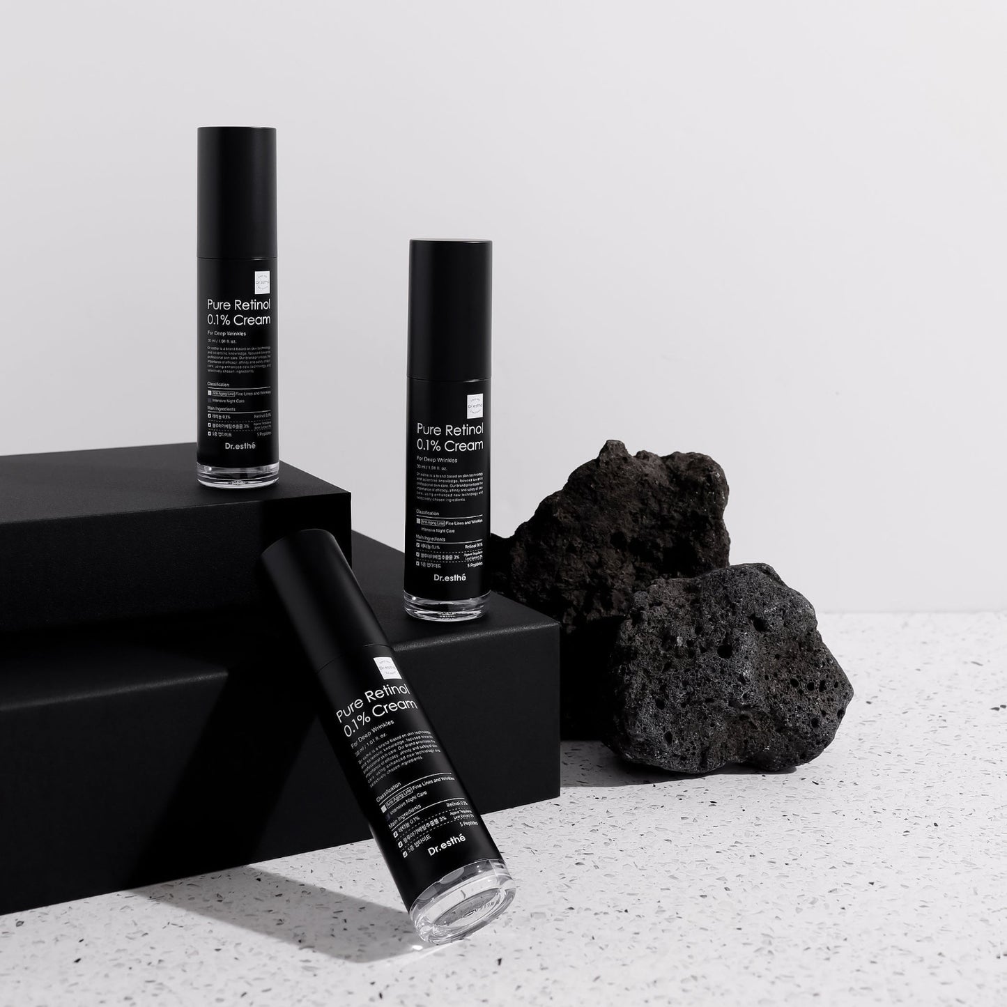 Dr. Esthé Retinol 0.1% Cream displayed with minimal black packaging and stone for premium skincare branding.