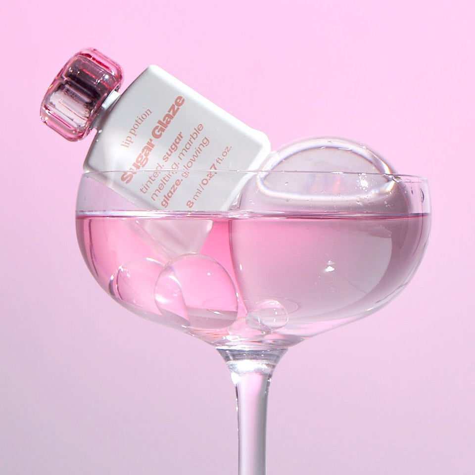 Alternative Stereo Lip Potion Sugar Glaze in a pink glass – glossy, water-light lip tint.