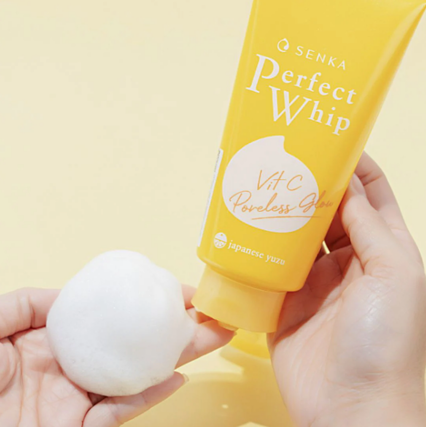 Senka Perfect Whip Vit C Cleanser showing fluffy foam texture on hand for brightening care.