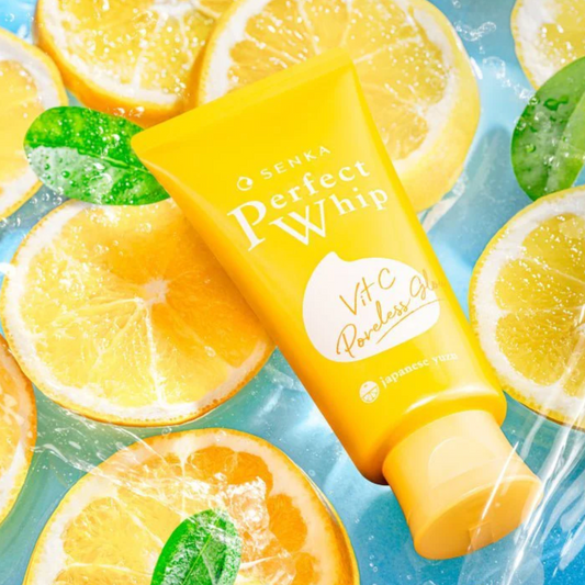 Senka Perfect Whip Vit C Cleanser with Japanese yuzu and lemon slices in fresh water background.