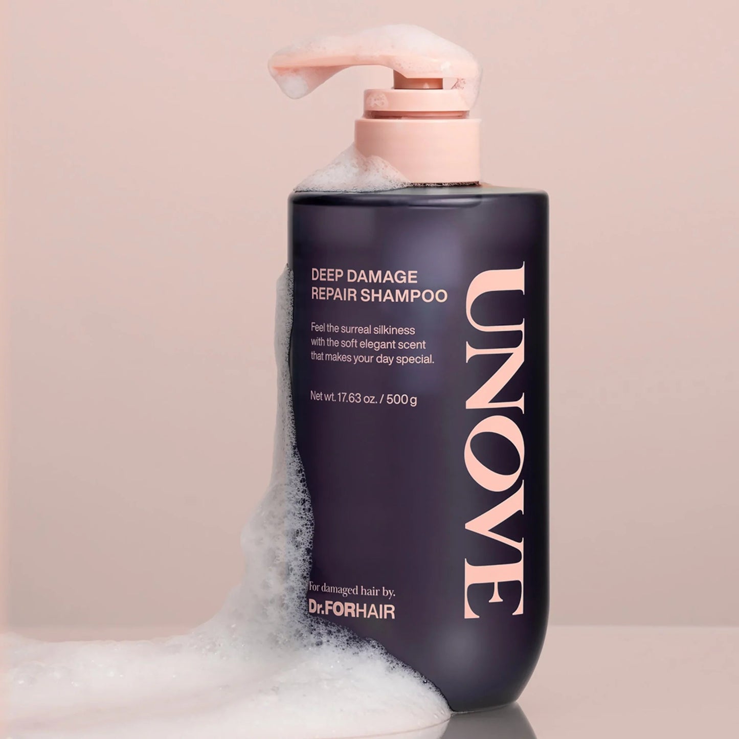 Close-up of UNOVE shampoo bottle covered in soft foamy bubbles.