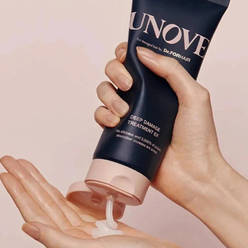 Squeezing UNOVE Deep Damage Treatment EX onto hand during hair care routine.