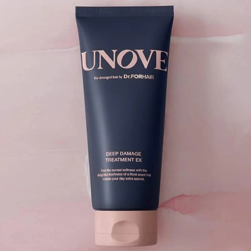 Front view of UNOVE Deep Damage Treatment EX tube on pink surface.