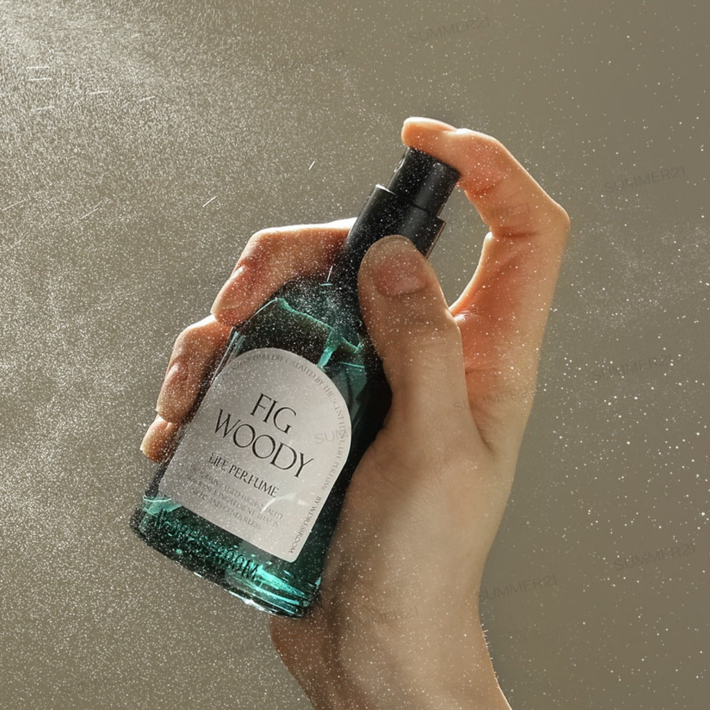 Hand spraying W.Dressroom Fig Woody Life Perfume into the air.