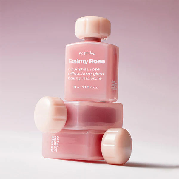 Stacked bottles of Alternative Stereo Balmy Rose – soft glam rose lip potion for moisture and shine.
