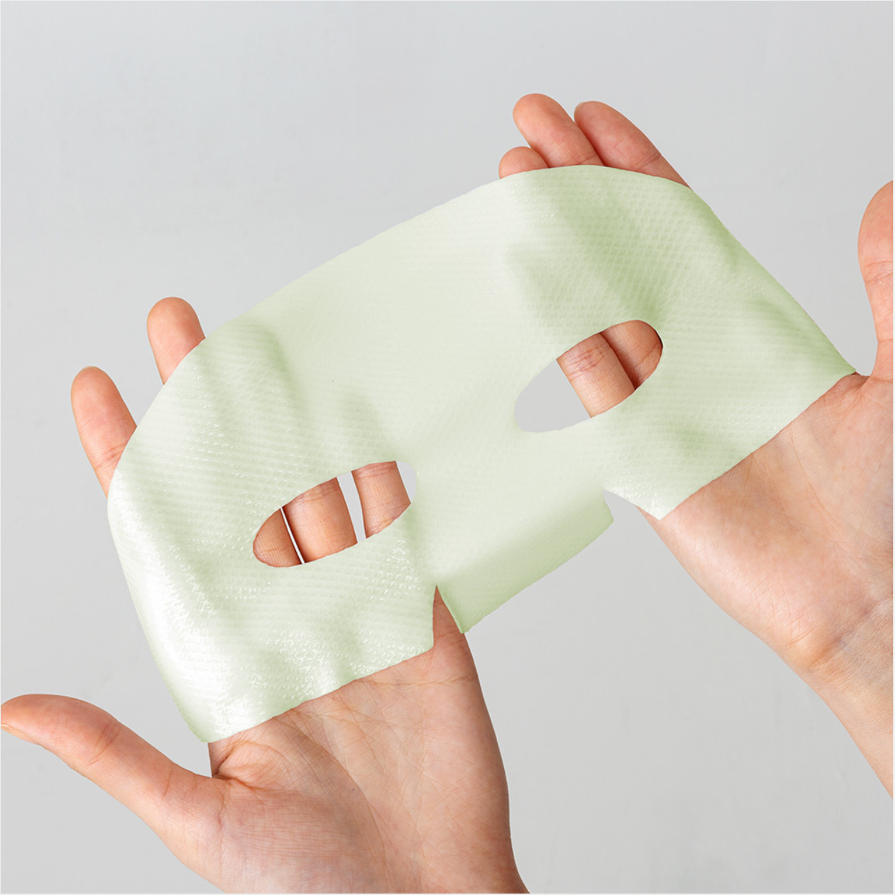 Close-up of Dermafix CICA Collagen mask sheet with soft green texture for calming skin.