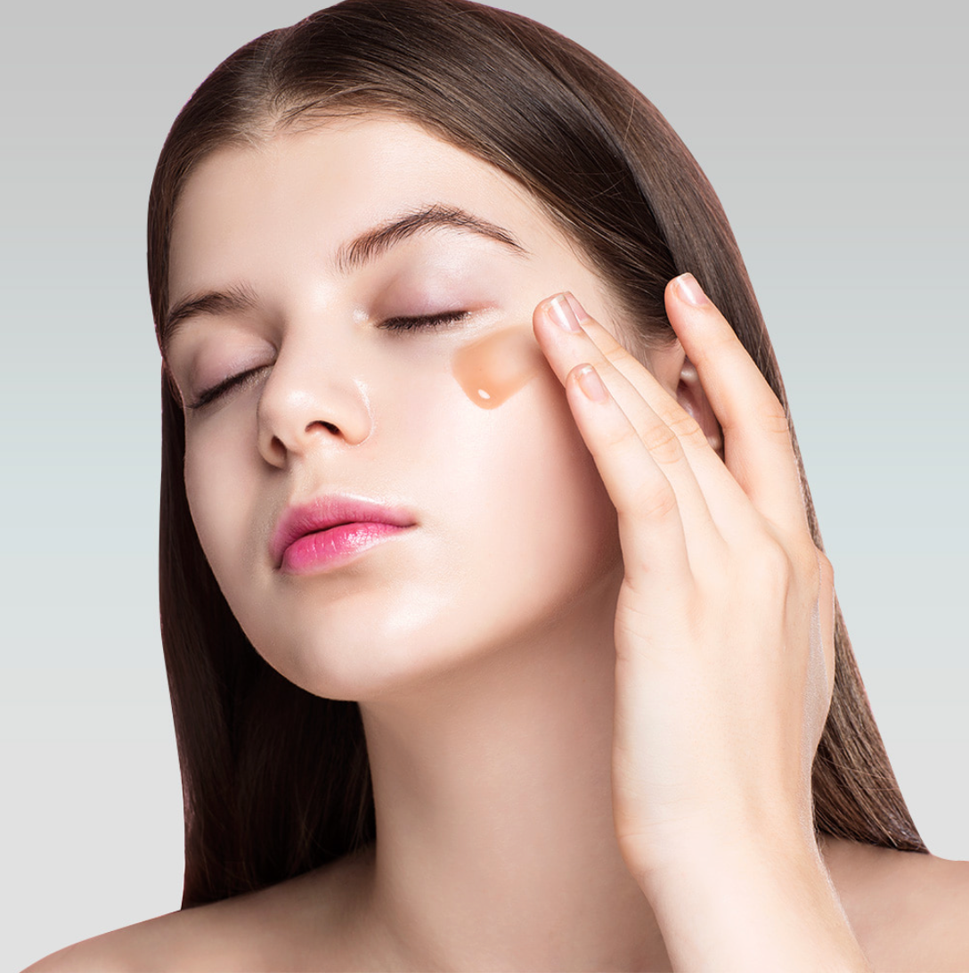 Model applying Dermafix Collagen Tension-up Cream under eyes with glowing skin.