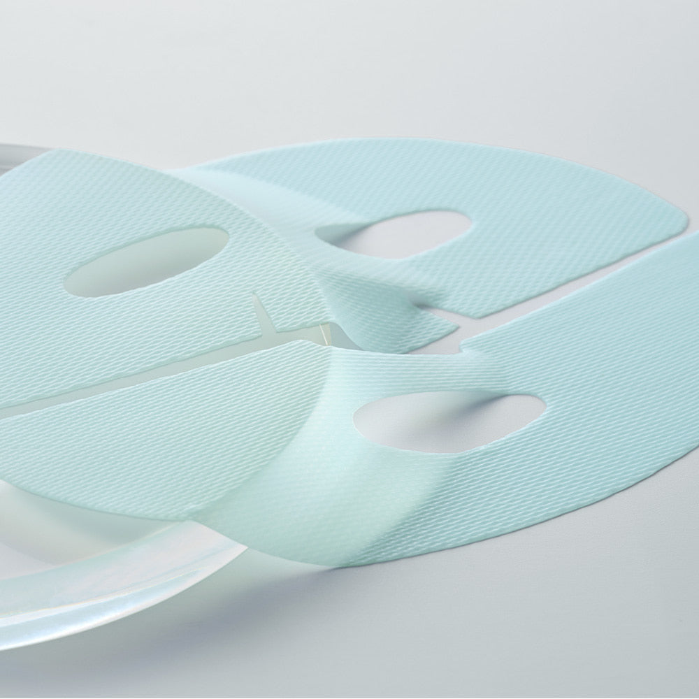 Close-up of Dermafix HYAL Collagen hydrogel sheet mask with aqua tint laid flat on a clear surface.