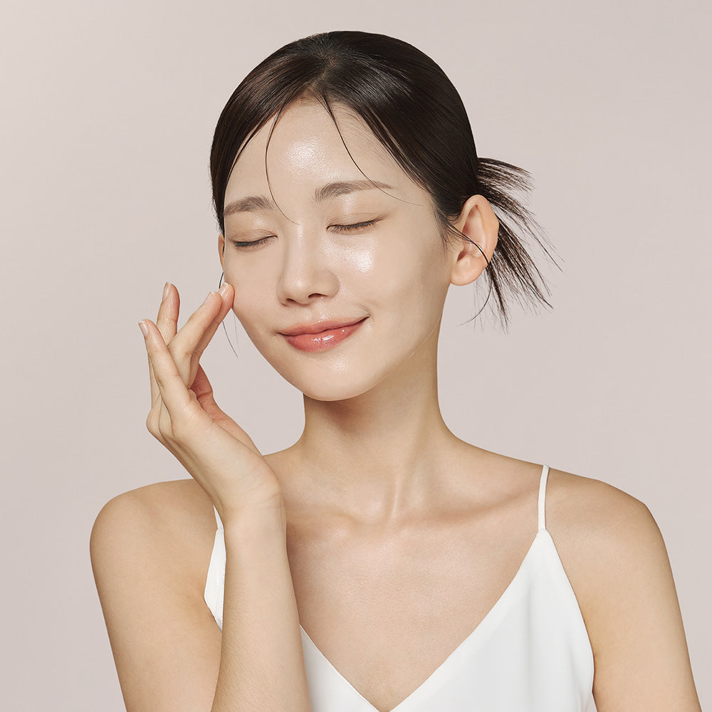Model touching her cheek with a radiant glow after using Dermafix Slow Aging Lift Up Mask.