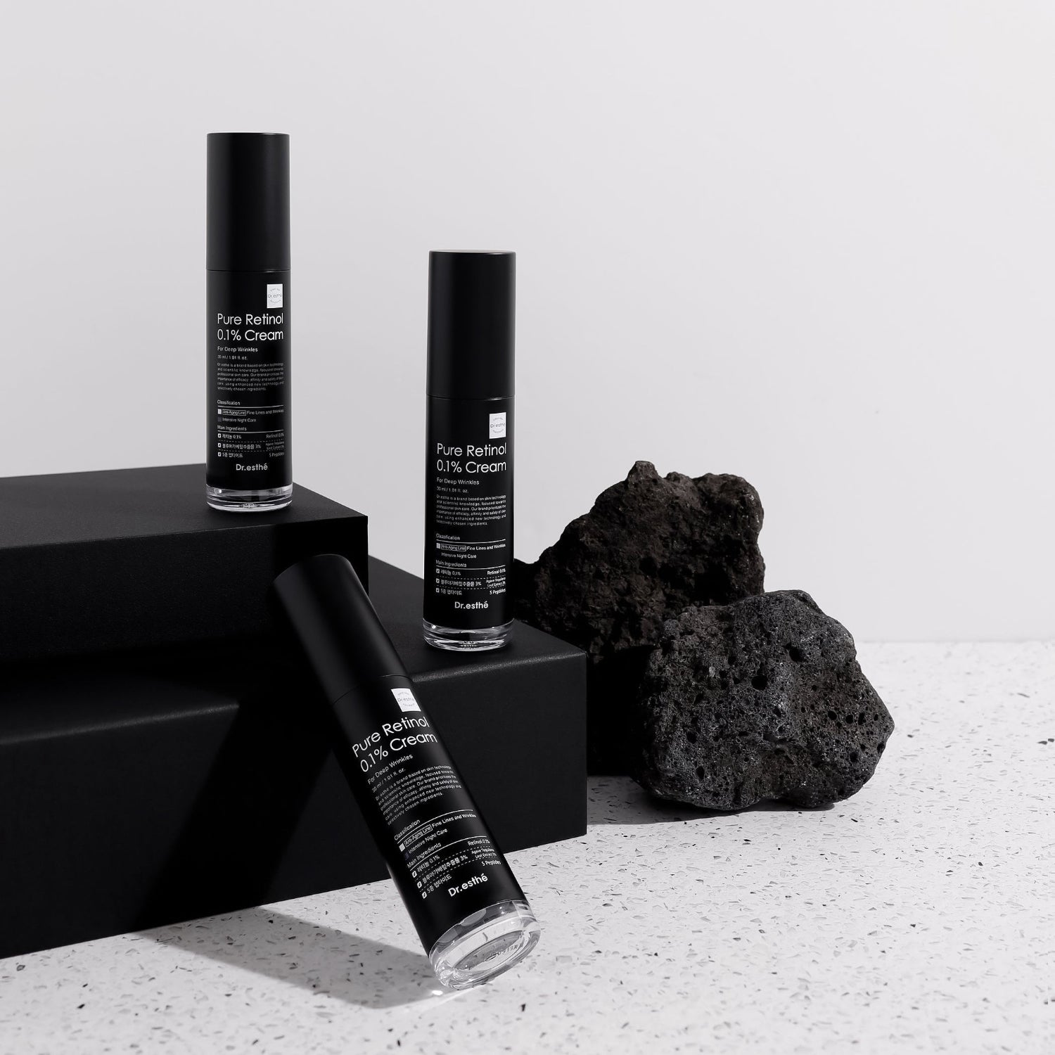 Dr. Esthé Retinol 0.1% Cream displayed with minimal black packaging and stone for premium skincare branding.