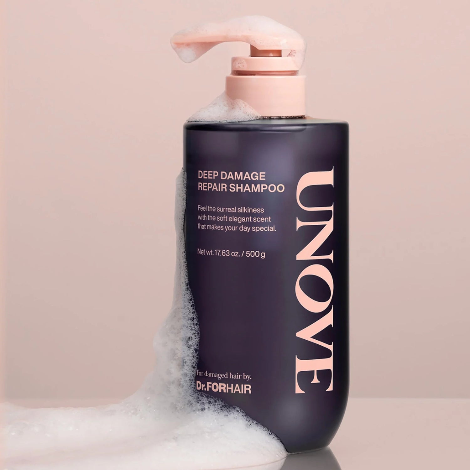 Close-up of UNOVE shampoo bottle covered in soft foamy bubbles.