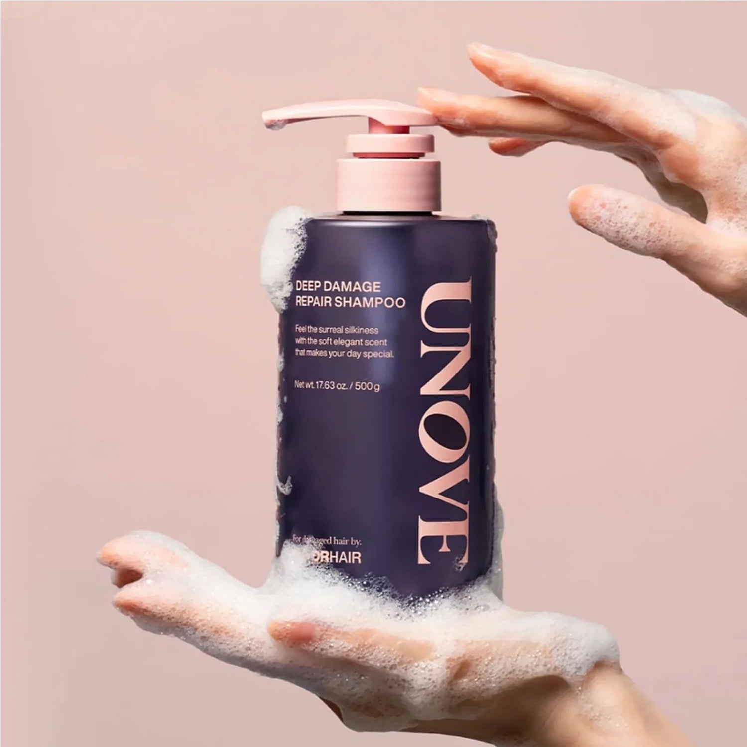 UNOVE Deep Damage Repair Shampoo foaming in hands with soft pastel background.